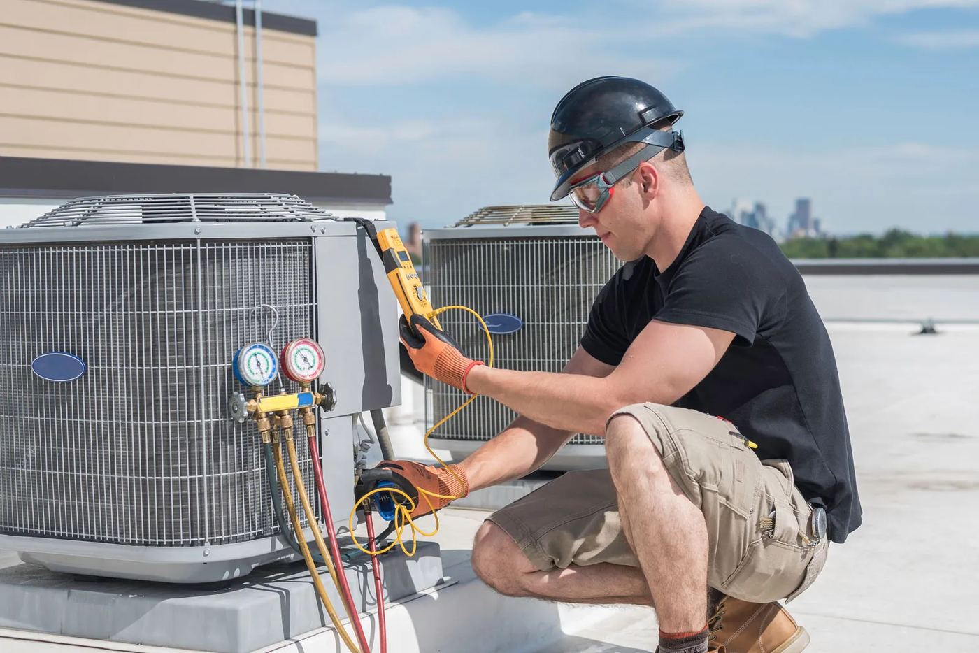 HVAC technician taking readings on a rooftop condenser