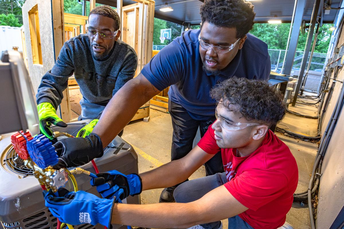 Crew working together on a condensing unit